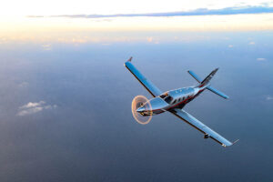 A Daher TBM 960 airplane soars in the sky at sunset